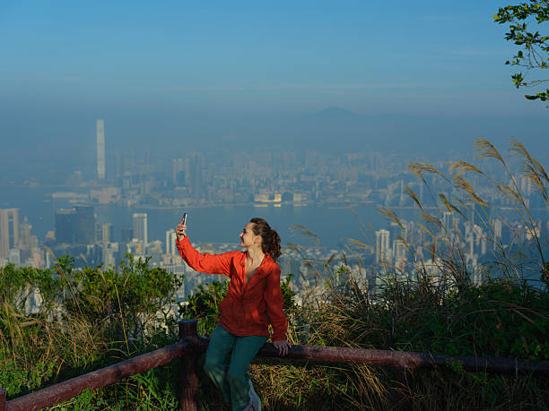 istock Woman using smartphone on viewpoint overlooking Hong Kong cityscape 2214898083