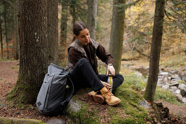 istock Woman Relaxing in Forest While Drinking from Water Bottle 2214900787