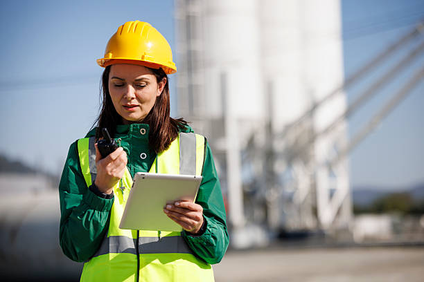 istock Female Construction Manager Using Walkie-Talkie and Digital Tablet on Site 2214904237