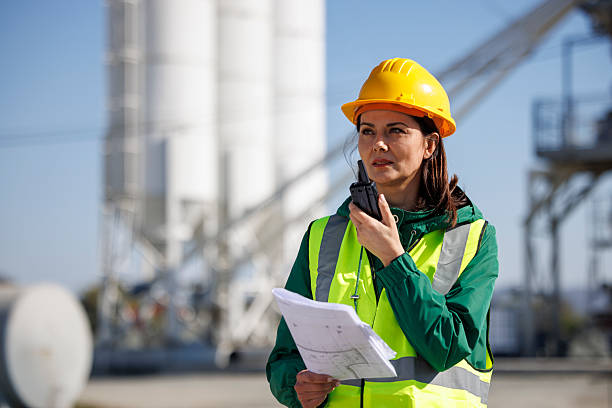 istock Female Construction Manager Using Walkie-Talkie and Digital Tablet on Site 2214904776