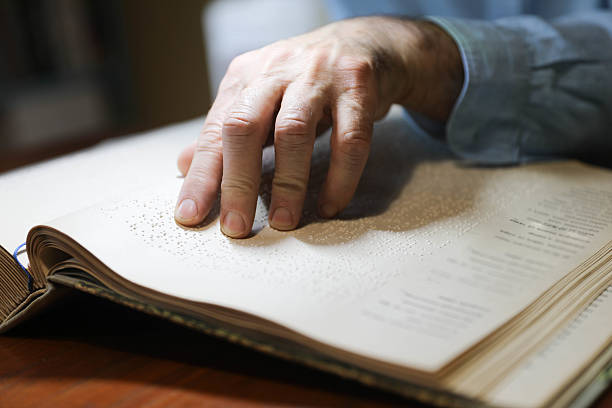 istock Blind Woman Over 50 Reading Braille Book 2214905736