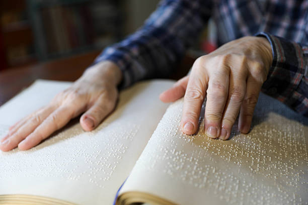 istock Blind Woman Over 50 Reading Braille Book 2214905774