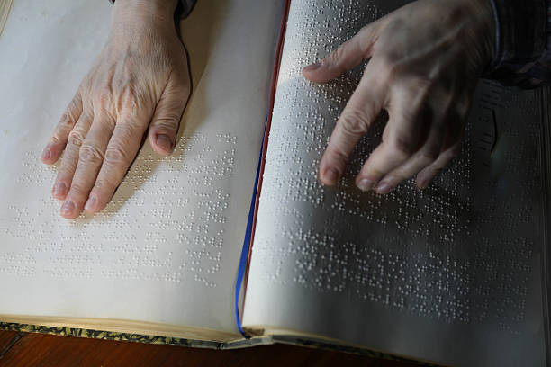 istock Blind Woman Over 50 Reading Braille Book 2214905801