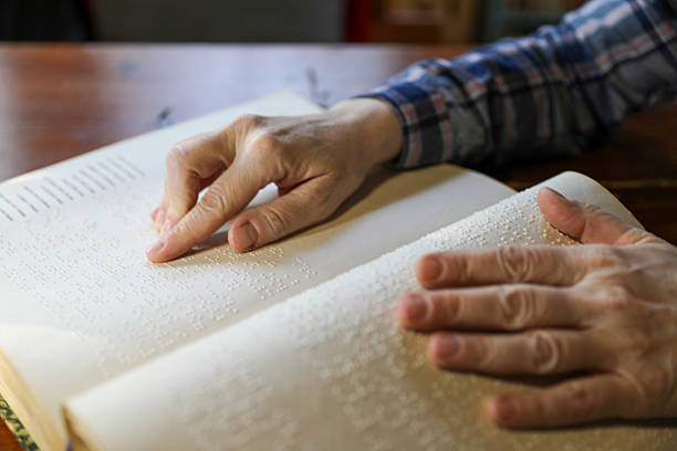 istock Blind Woman Over 50 Reading Braille Book 2214905836