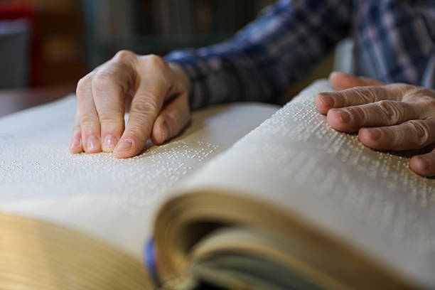 istock Blind Woman Over 50 Reading Braille Book 2214905838