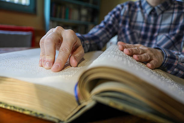 istock Blind Woman Over 50 Reading Braille Book 2214905896