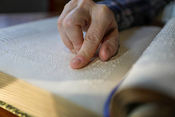 istock Blind Woman Over 50 Reading Braille Book 2214905907