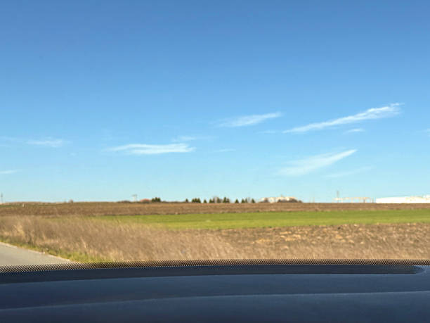 Nature view from inside the car. Travel concept. Green field and clear sky background