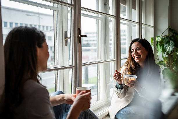 istock Two female friends enjoying breakfast and conversation by the window 2214908900