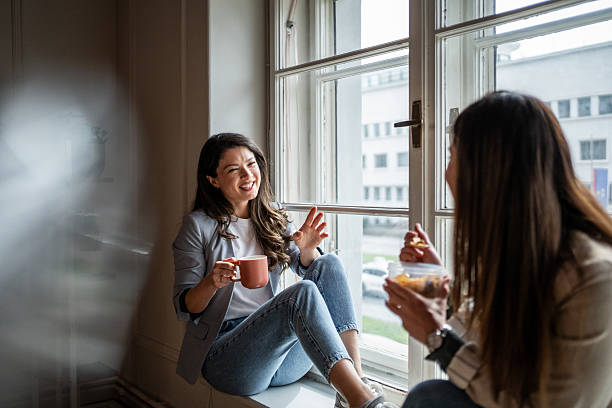 istock Two businesswomen chatting by the window during coffee break 2214908974