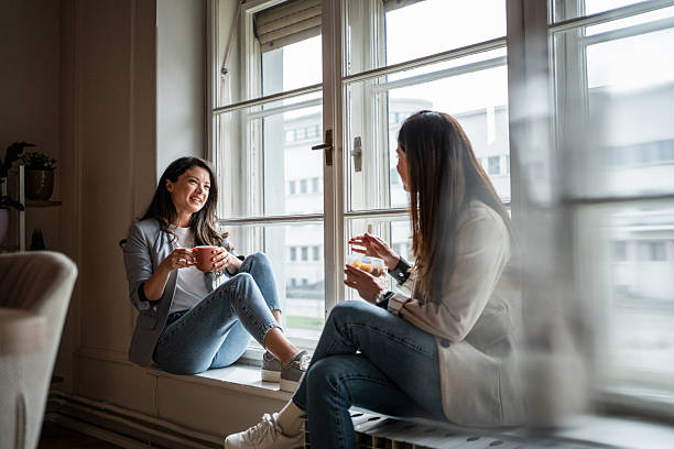 istock Two young businesswomen chatting by the window during coffee break 2214908977