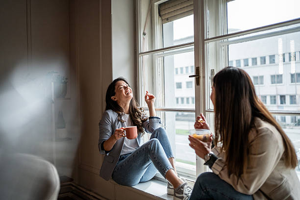 istock Two businesswomen taking a break, laughing and chatting by the window 2214908978