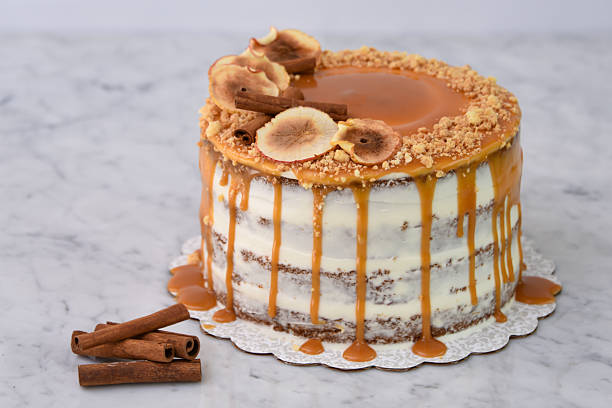 istock Caramel Fig Drip Cake featuring layers of moist cake drizzled with rich caramel, topped with dried fig slices, cinnamon, and chopped nuts isolated on background closeup side view of baked dessert 2214910027