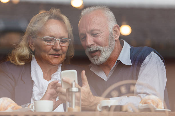 istock Senior couple enjoying time together while using a smartphone 2214910074