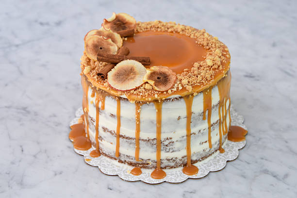 istock Elegant Caramel Fig Drip Cake featuring layers of moist cake drizzled with rich caramel, topped with dried fig slices, and chopped nuts isolated on background side view of baked cafe dessert 2214910583