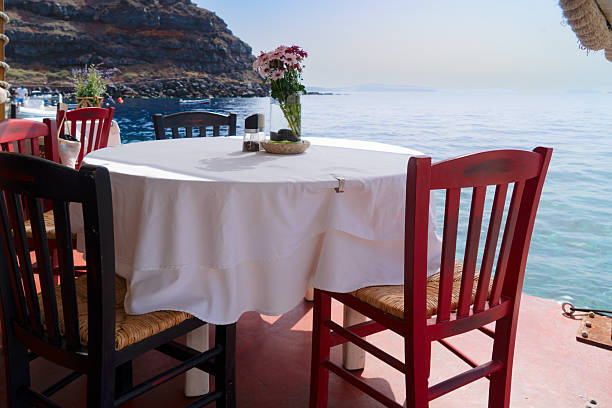 chairs and dinner table with view of caldera, Santorini, Greece
