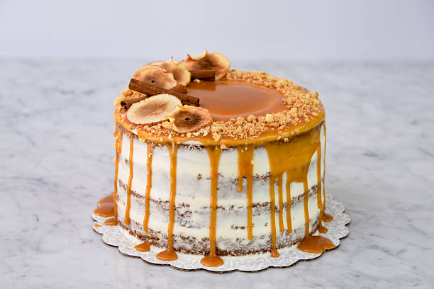 istock Caramel Fig Drip Cake featuring layers of moist cake drizzled with rich caramel, topped with dried fig slices, and chopped nuts isolated on grey background side view of baked dessert 2214910705