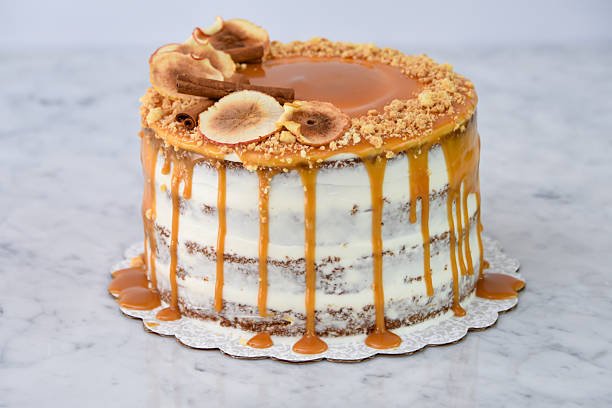 istock Elegant Caramel Fig Drip Cake featuring layers of moist cake drizzled with rich caramel, topped with dried fig slices, and chopped nuts isolated on background closeup side view of baked cafe dessert 2214910934