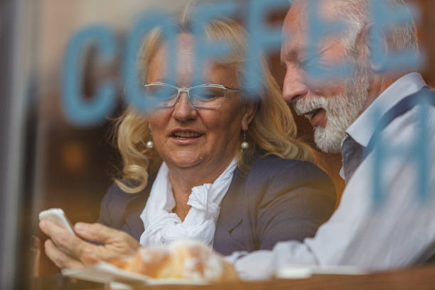 istock Senior friends enjoying coffee and technology in a cozy cafe setting 2214911440
