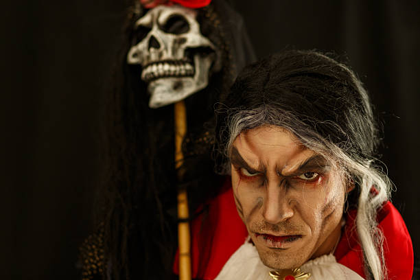istock Gothic Themed Portrait of a Dark Character with a Skull Backdrop 2214913099