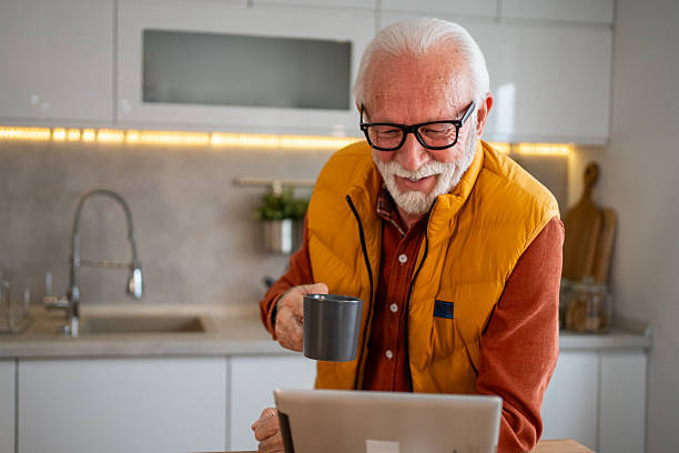 istock Senior man enjoying a cup of coffee while using his tablet in the kitchen 2214915061