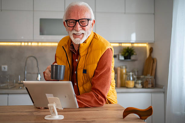 istock Senior man enjoying coffee and digital tablet in kitchen 2214915078