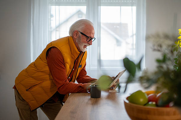 istock Senior man using digital tablet at home in living room 2214915099