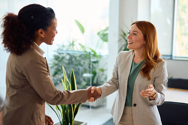 istock Two businesswomen shaking hands in modern office 2214924556