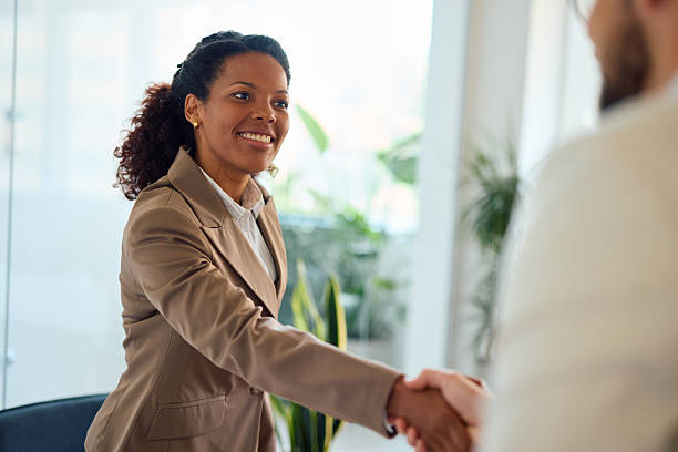 istock Two business people shaking hands in a modern office 2214924764