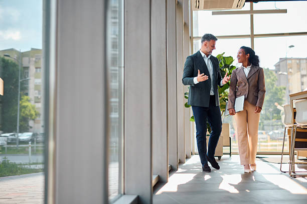 istock Businesspeople walking and talking in modern office corridor 2214925670