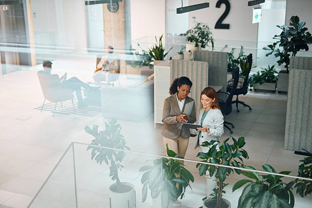 istock Two businesswomen discussing over digital tablet in modern office 2214925835