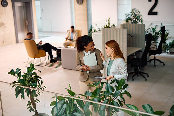 istock Two businesswomen talking and smiling in modern office 2214926032