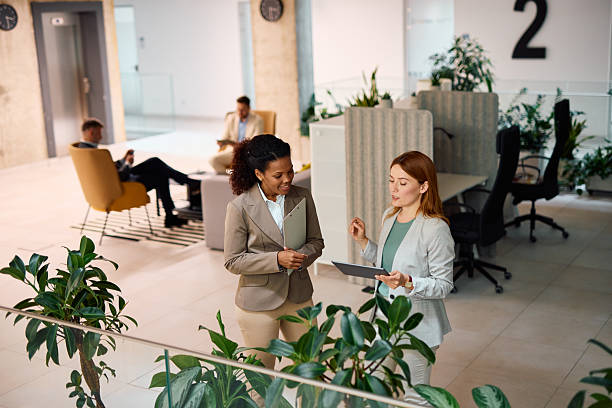 istock Two businesswomen discussing using tablet and clipboard in modern office 2214926118