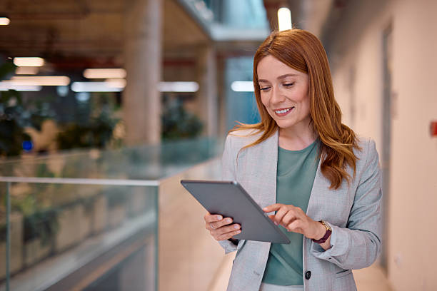 istock Smiling businesswoman using digital tablet in modern office building 2214926450