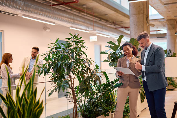 istock Businesspeople discussing over digital tablet in modern green office space 2214926728