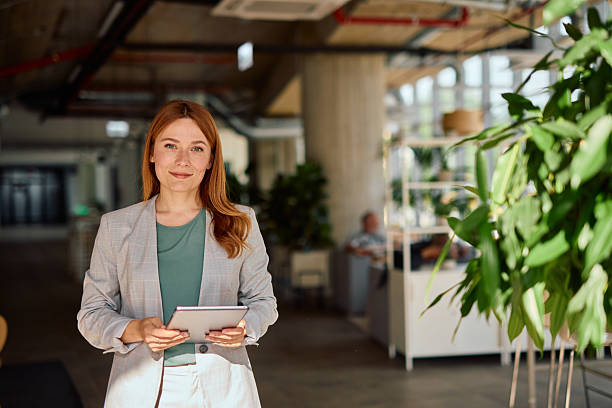 istock Businesswoman holding tablet looking at camera in modern office 2214928174