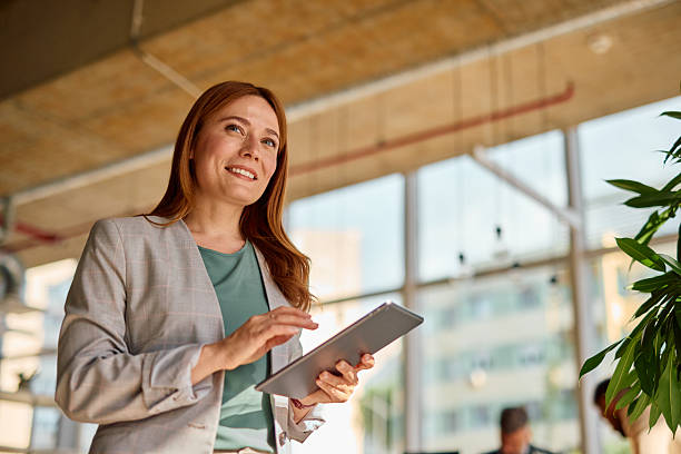 istock Businesswoman smiling and using digital tablet in modern office 2214928272