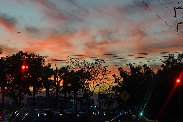 Fiery Sunset Hues Over Silhouetted Highway Traffic.