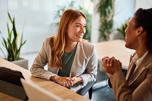 istock Two businesswomen discussing sitting at a table in a modern office 2214929059