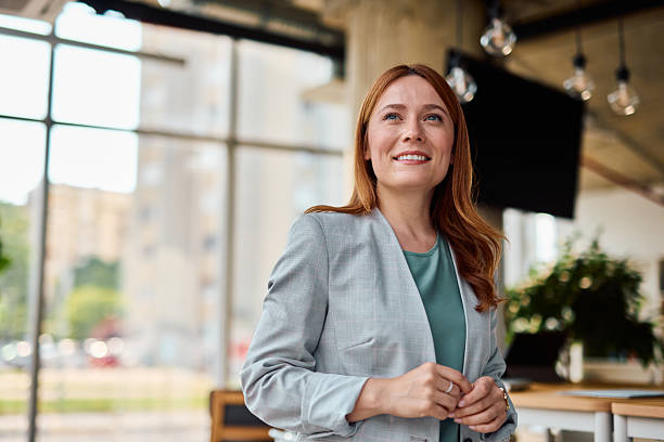 istock Smiling businesswoman looking up in modern office 2214929100