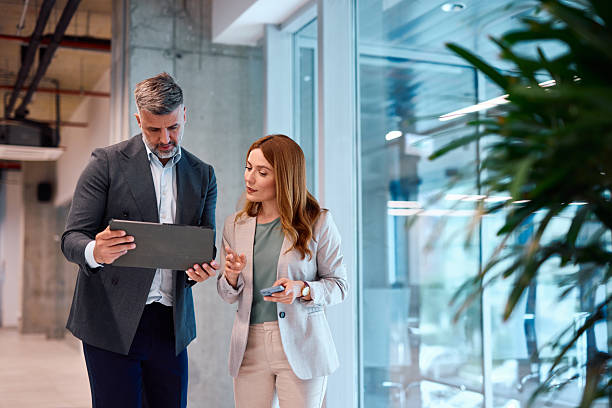 istock Business partners reviewing notes on a clipboard in an office hallway 2214929500
