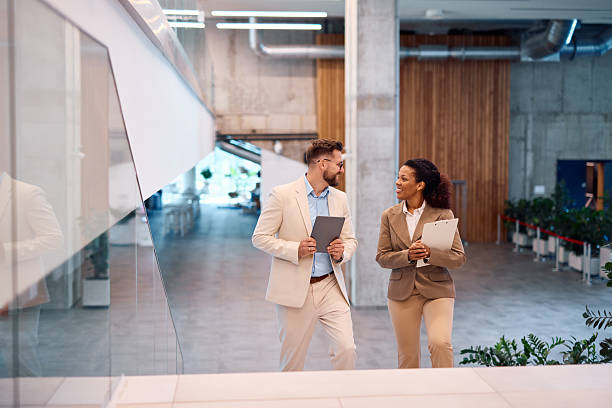istock Businesspeople walking and talking in modern office building lobby 2214929708