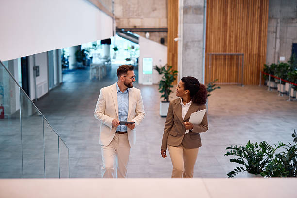 istock Business partners walking and talking in modern office building lobby 2214929713