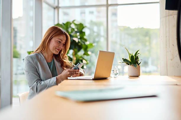istock Businesswoman using smartphone and laptop in modern office 2214929845