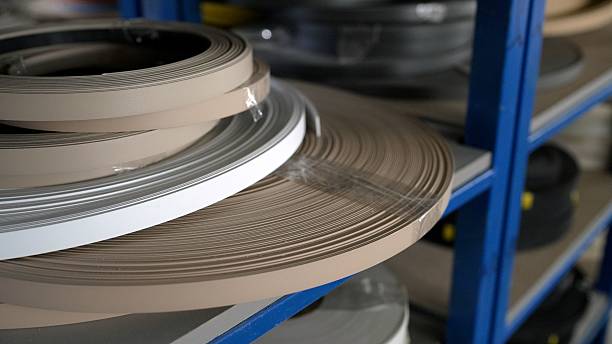 istock Plastic edge banding rolls rotating on shelf in factory 2214931176