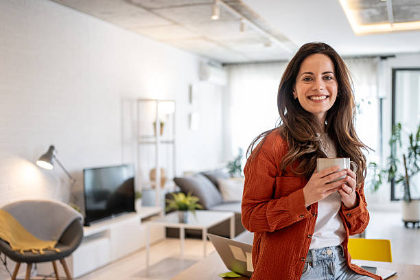 istock Young woman enjoying a cup of coffee while working from home 2214935584