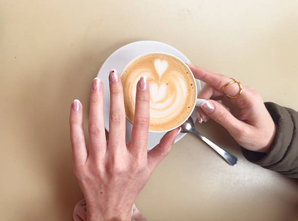 istock Woman enjoying cappuccino with latte art during coffee break 2214936879