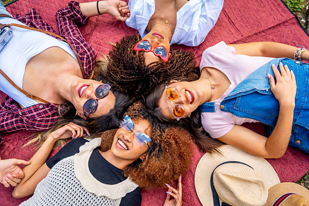 istock Four young women lying in circle on blanket wearing sunglasses 2214938076