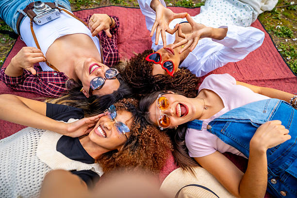 istock Four young women taking a selfie, lying on a blanket and making heart shape with hands 2214938082