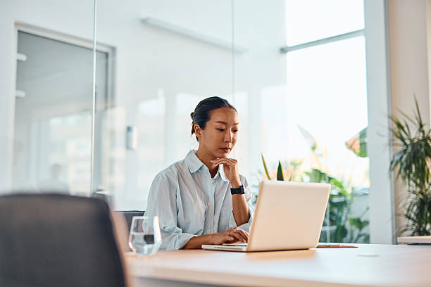 istock Focused businesswoman working on laptop in modern office 2214938979